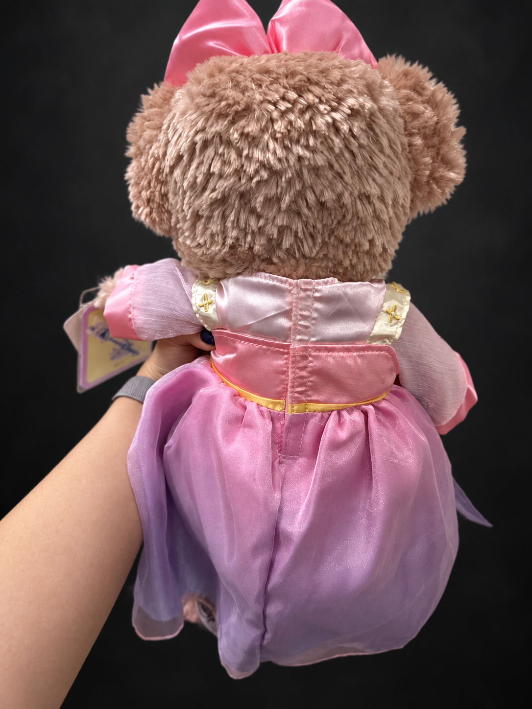 Edited rear-view photo of the actual ShellieMay plush and pink costume on charcoal background