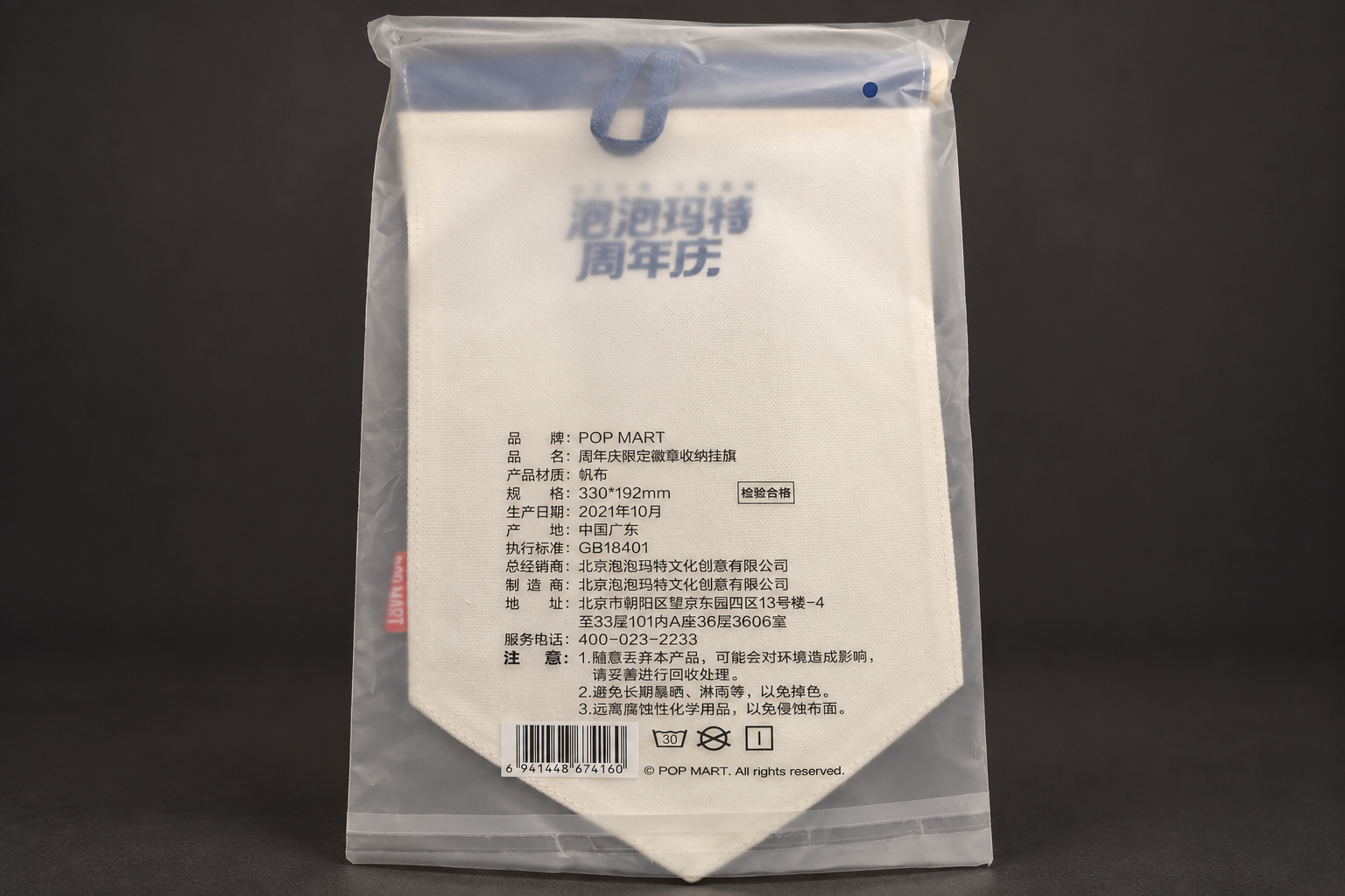 The back of a white pennant-shaped flag in a clear bag, with a printed product label and barcode