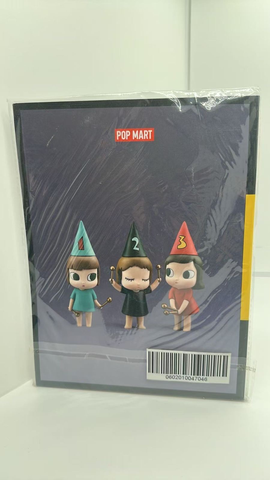 Back cover of PLAYGROUND VOL.02 in its clear outer bag, with a photo of three figures in party hats and a barcode