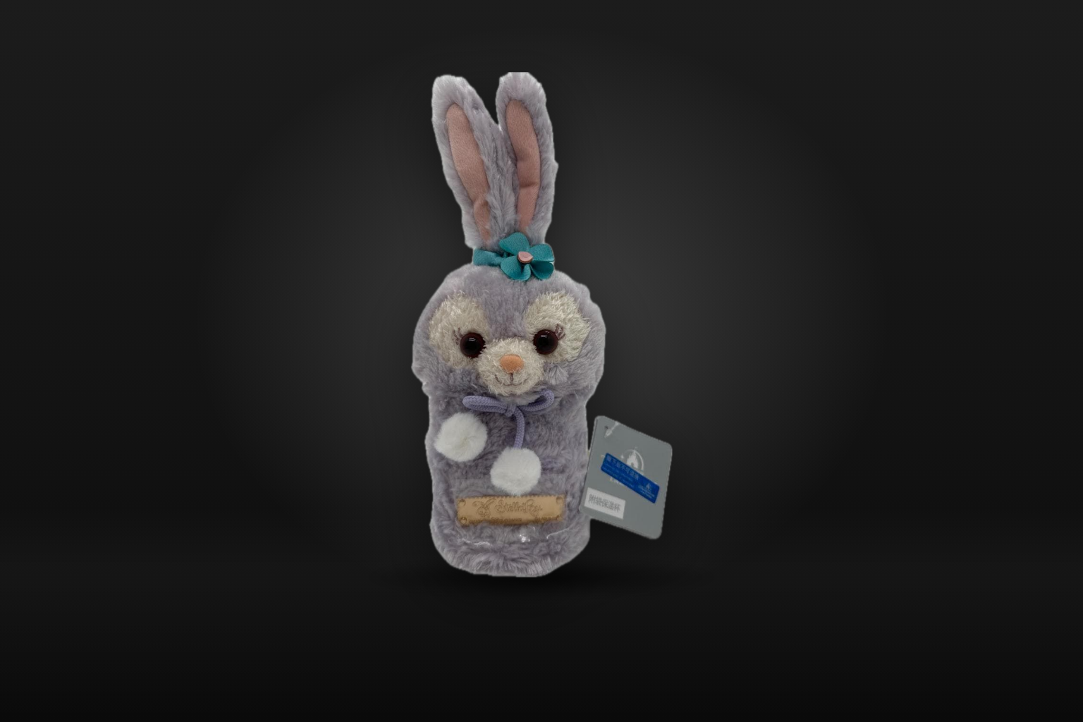 A StellaLou plush bottle cover with a grey Shanghai Disney Resort tag, standing alone on a dark background