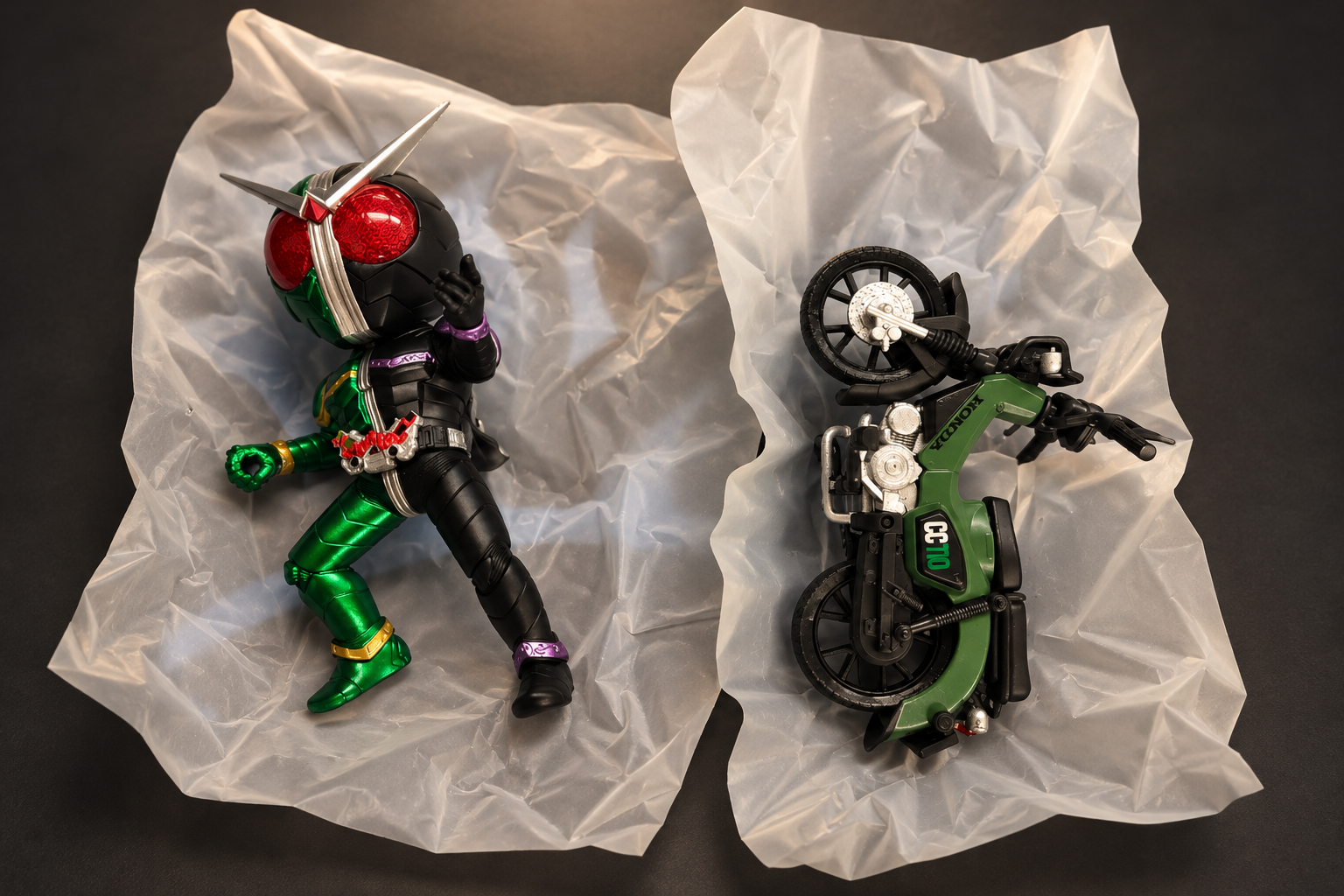 A chibi Kamen Rider W figure, half green and half black, next to a green Honda CROSS CUB style bike on a dark grey background