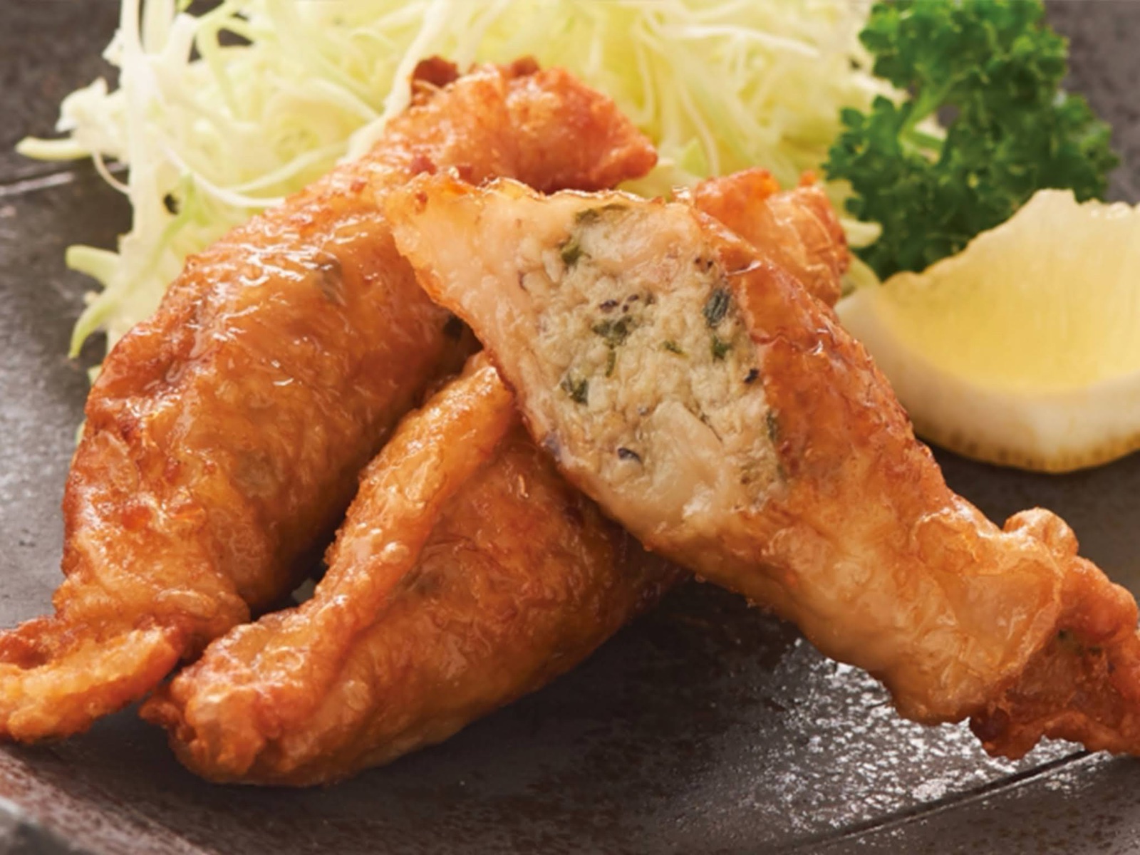 Fried tebagyoza with shredded cabbage, parsley and lemon, one cut open to show the filling (unedited photo)