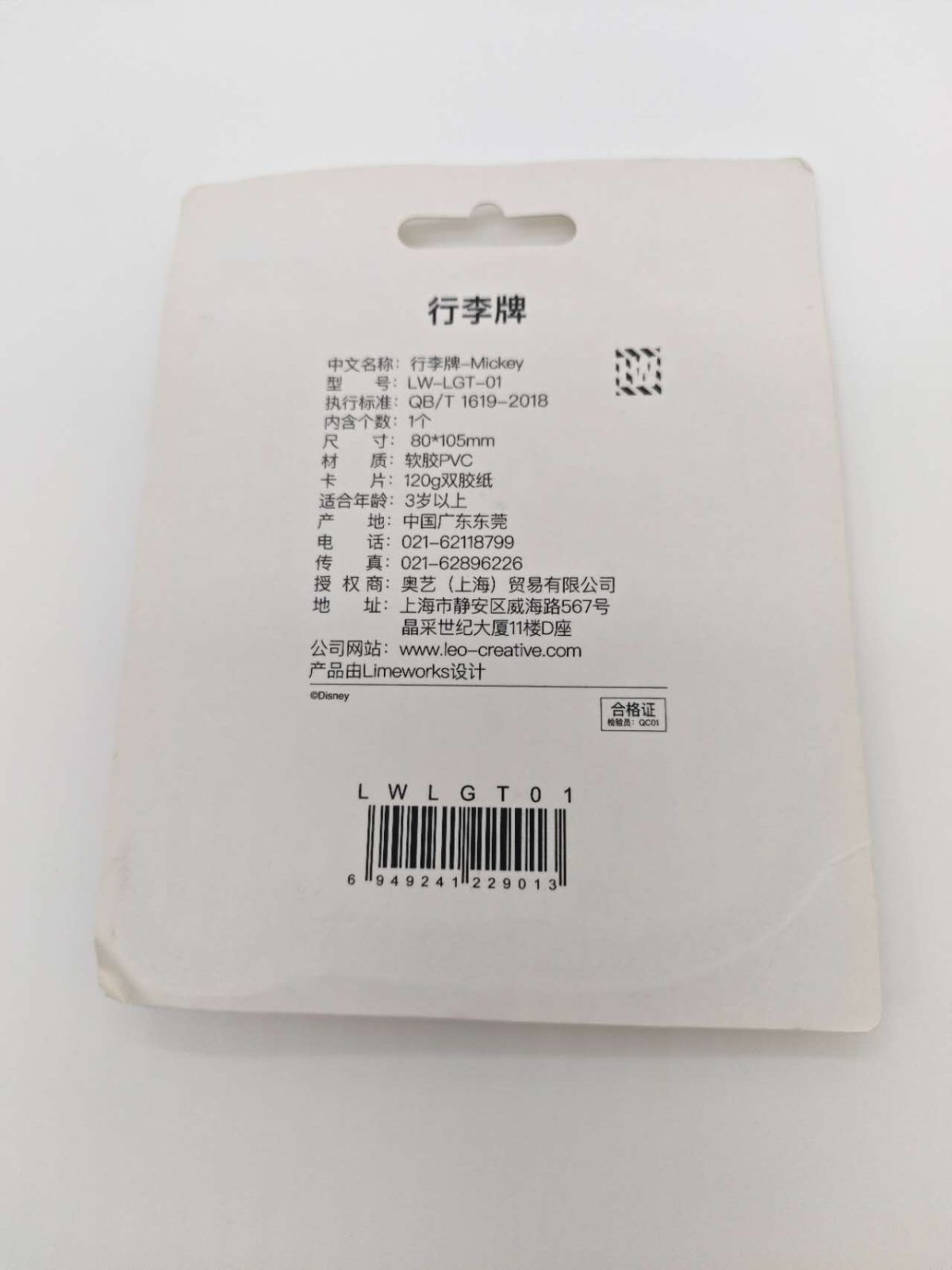 ミッキーマウスのラゲッジタグの台紙裏面。「行李牌」の見出しの下に、中文名称、型号、执行标准、尺寸、材质、适合年龄、产地などが中国語で並ぶ