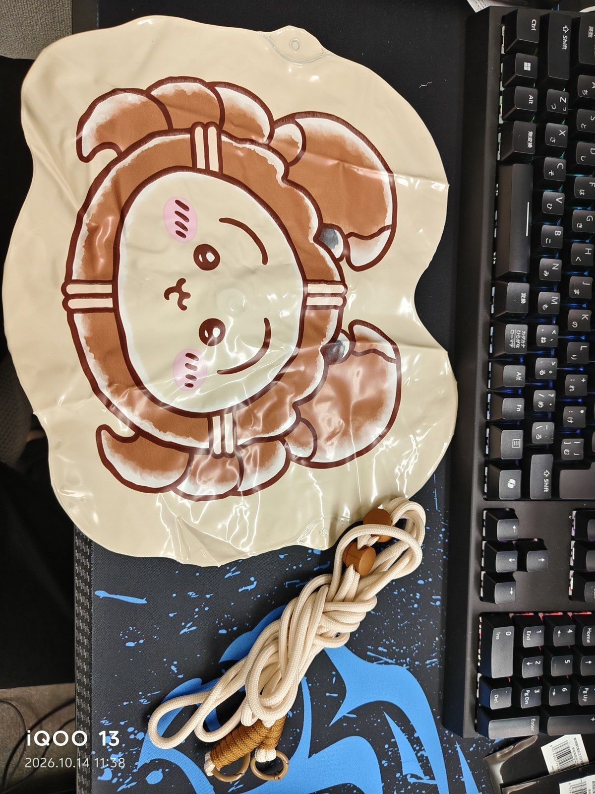 The cream vinyl bag printed with a face framed by a crab shell and claws, with a natural-colour rope strap (unedited photo; the camera's date stamp is visible at bottom left)