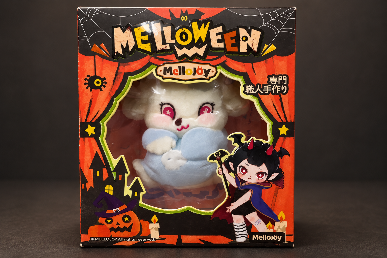 暗いグレーの背景に、オレンジ色のMellojoy「MELLOWEEN」の箱。窓からスクイーズ本体が見え、ハロウィンのイラストが描かれている