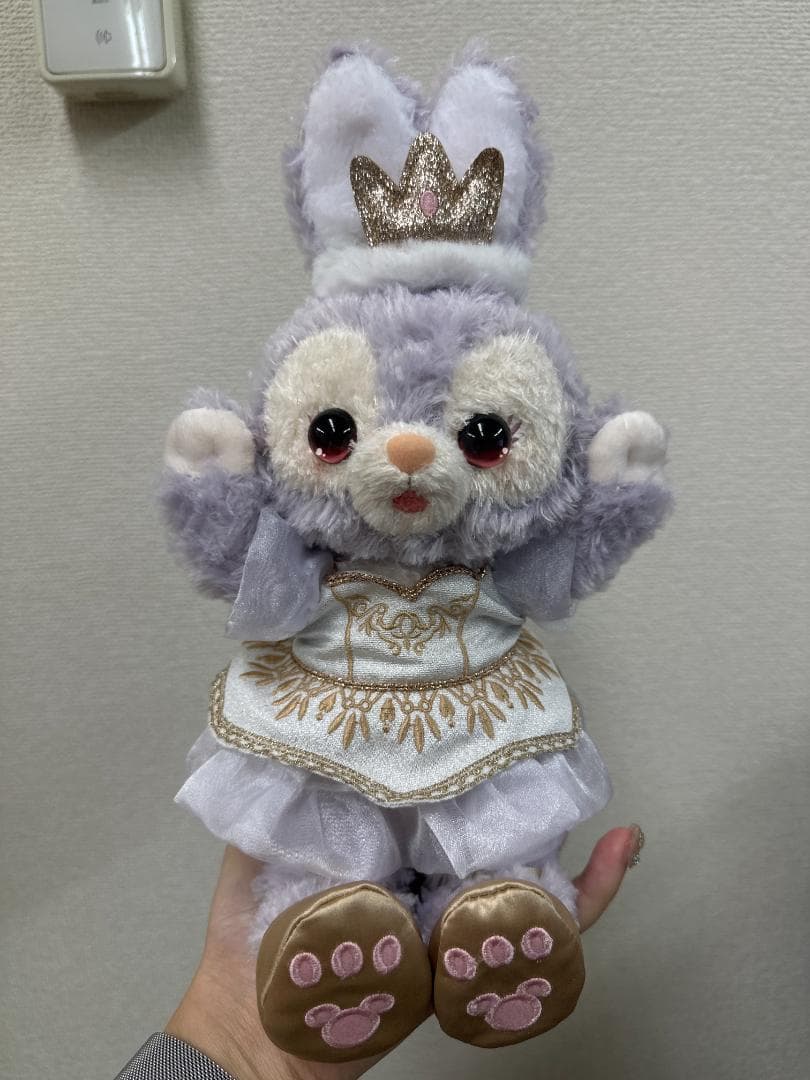 Front seller photograph with both arms lifted, crown and outfit visible