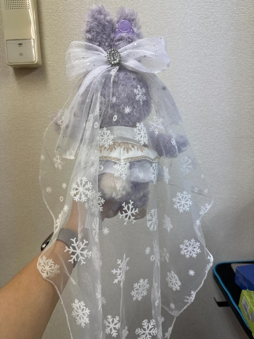 Back of a lavender custom rabbit plush wearing a white patterned veil